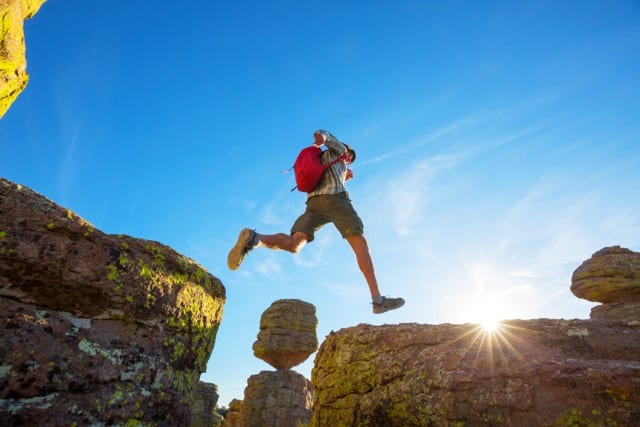 Un jeune homme saute d'un rocher à l'autre