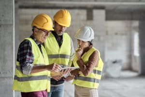 Trois travailleurs analysent les plans d'un projet de construction